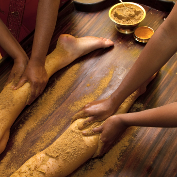indian doctors doing traditional ayurvedic oil foot massage